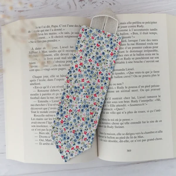 Marque pages en tissu avec un motif de mini fleurs bleues et rouges sur fond blanc